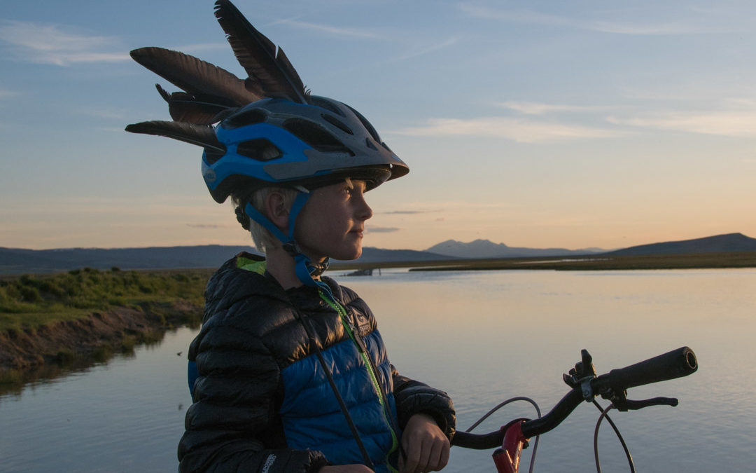 Boy with goose feathers in bike helmet